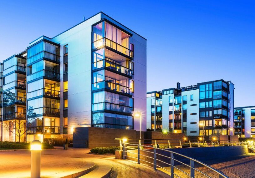 A group of buildings with lights on the outside.