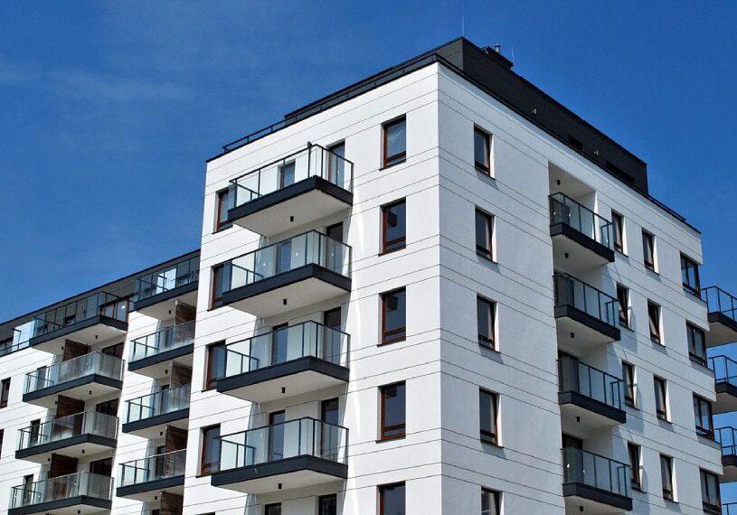 A white building with balconies on the top of it.